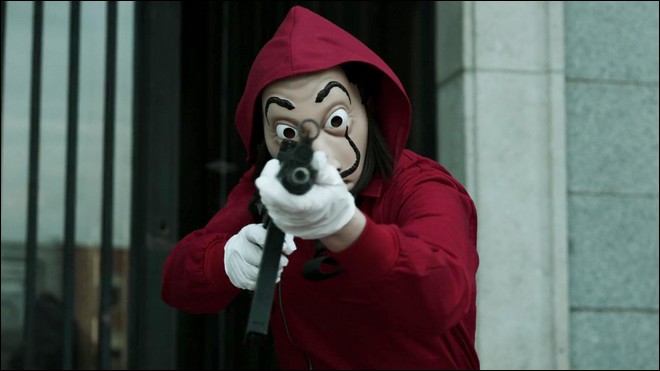 Un braqueur portant un masque de Dali pointe son arme sur la police